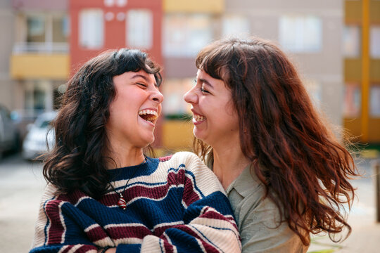 Cheerful Couple Laughing Outside Their New Apartment