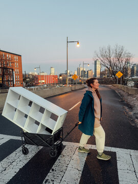 Woman Pulling Wagon with Shelf in Jersey City at Dusk