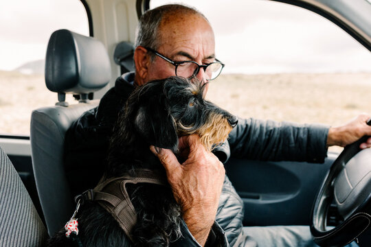 Elderly man and his dachshund traveling by car
