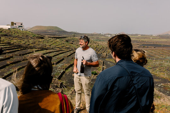 Man who runs a family vineyard addressing a small group of travelers