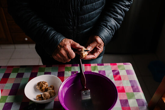 Close-up of an unidentified elderly man carefully cleaning truffles
