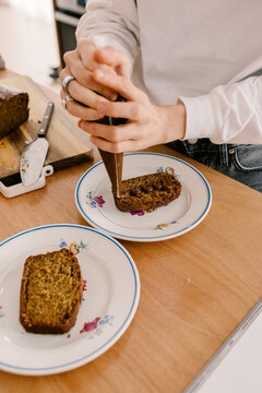 Unknown woman using a pastry bag to decorate slices of cake