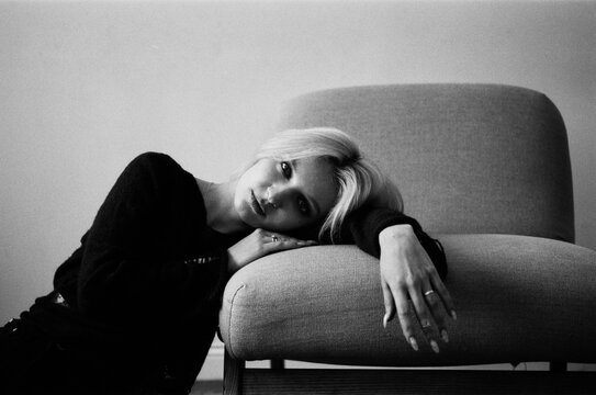 Contemplative Blonde Resting Head on Sofa in B&W Portrait 