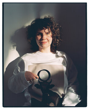 Woman with curly hair points at the moon on a shirt