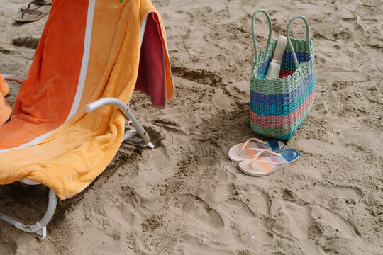 Colorful summer Beach Essentials,, Towel, Bag and Flip Flops on Sand
