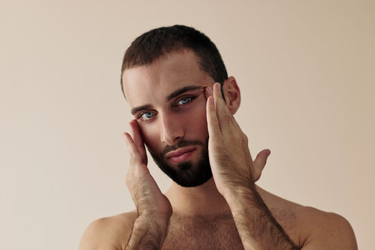 Man Touching His Face in a Simple Background Setting