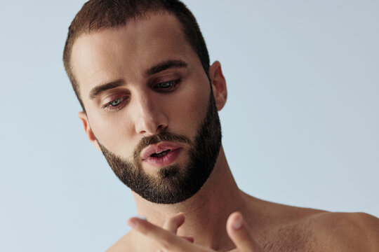 Man With Beard Focuses on Hand Gestures in Studio Setting