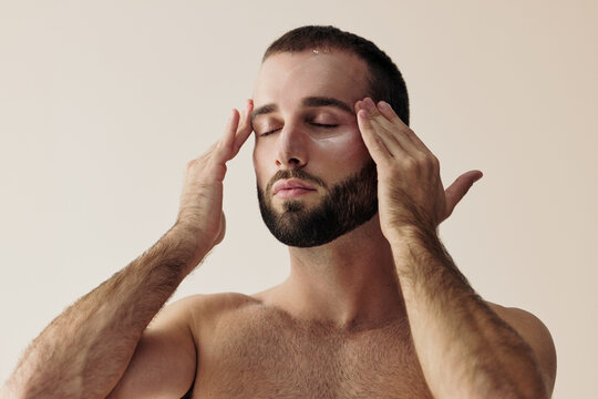 Man Performs Facial Massage in Simple Indoor Setting