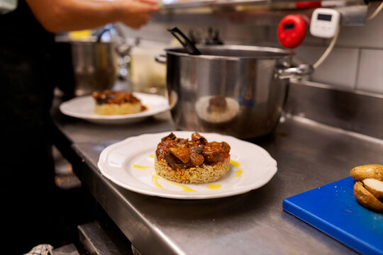 Chef Prepares Dish in Busy Kitchen at Restaurant
