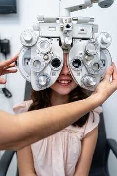 Optometrist Adjusting Phoropter For Teen Patient
