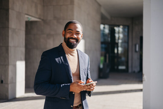Happy businessman stands outdoors