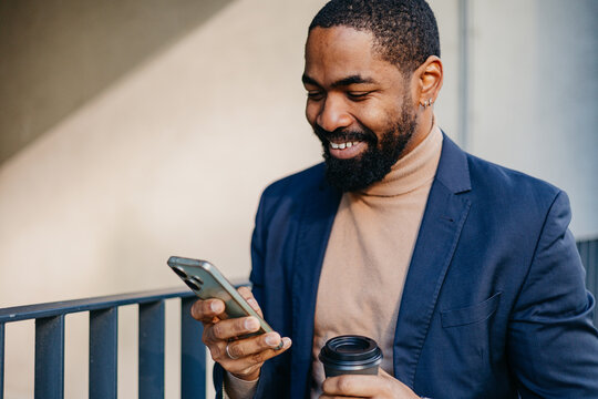 Businessman smiles as he checks his phone