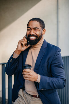 Stylish man speaks on the phone outdoors