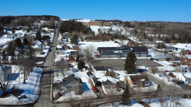 Drone footage flying over Lac-au-Saumon, showcasing the snowy schoolyard, village homes, and a former convent now serving as a seniors&rsquo; residence in Quebec&rsquo;s Matapedia Valley.