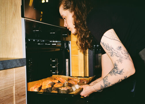 Woman Taking Baked Salmon from Oven &ndash; Analog Flash Photography