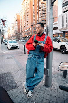 Young man using smartphone on urban street