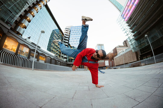 Breakdancer performing power move in city square