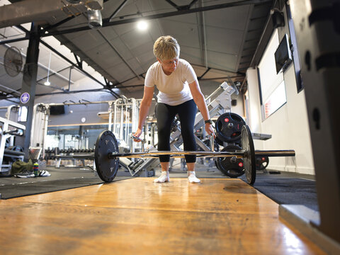 Woman Lifts Weights in Gym During Morning Workout Session
