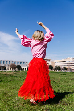 Woman dancing outdoors in red skirt