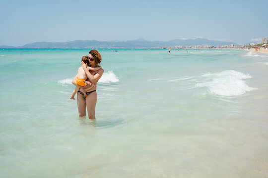 A woman with her son at the beach in summer
