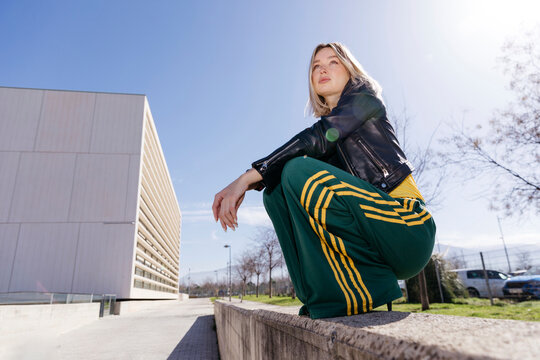 Woman squatting city street 