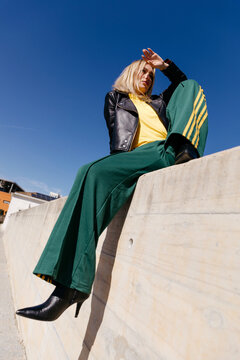 Woman sitting against blue sky