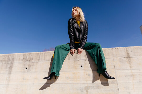 Woman confidently posing on concrete wall