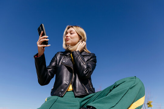 Woman taking selfie with smartphone outdoors