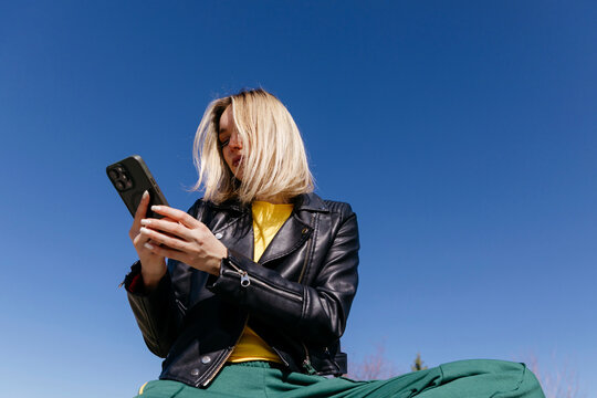 Woman using smartphon on clear sky
