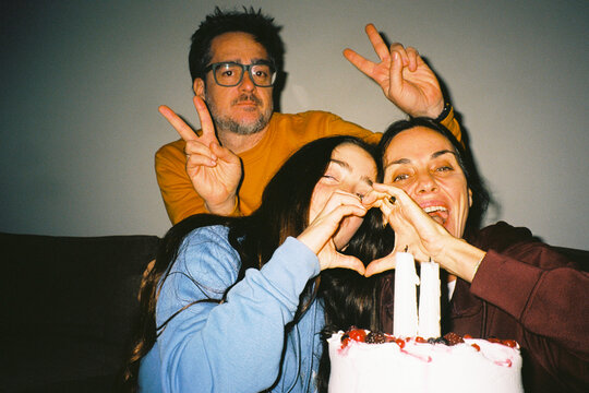 Family heart gesture with birthday cake