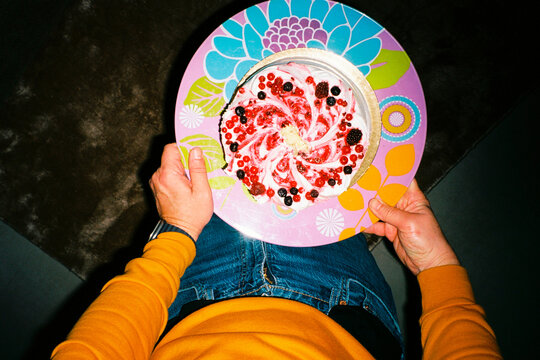 Hands holding berry cake plate