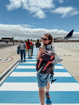 Woman Boarding Airplane on Airport Runway