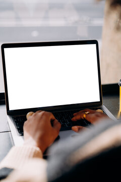 A woman using a laptop with a white screen