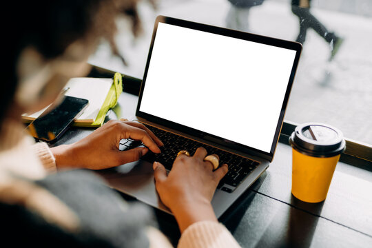 A woman using a laptop with a white screen