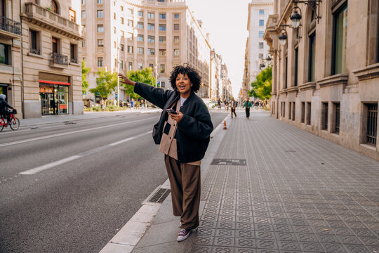 A woman catches a taxi in the city
