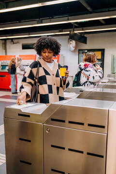 A woman passing through a subway turnstile