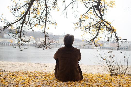 A man walks on the riverbank.