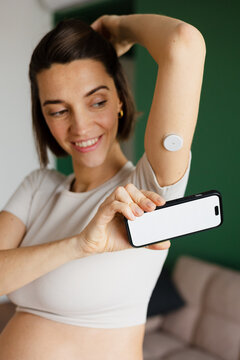 Pregnant woman monitoring glucose level using phone app