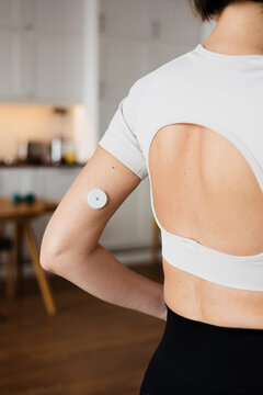 Woman wearing continuous glucose monitoring sensor on her arm