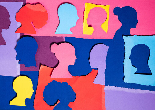 Paper Cutouts of Faces Arranged on Colorful Background