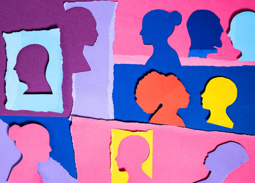 Paper Cutouts of Diverse Faces in Colorful Design on Wall