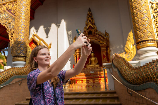 Tourist Takes Selfie in Front of Buddhist Temple in Thailand