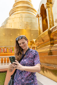 Tourist Takes Photos at Golden Temple in Thailand During Daytime