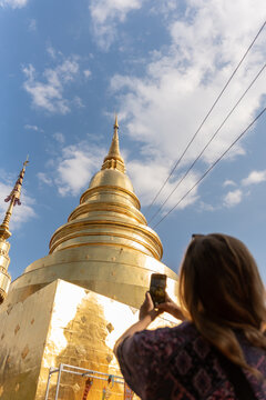 Visitor Takes Photo of Golden Stupa Under Blue Sky During Daytime