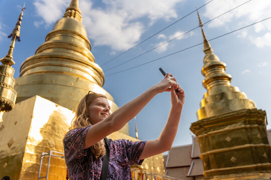 Visitor Takes Selfie at Golden Temple During Sunny Day in Thailand