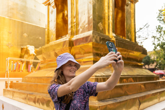 Woman Takes Selfie in Front of Golden Temple During Sunny Day
