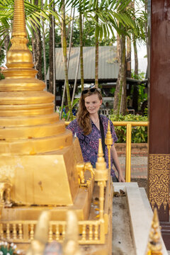 Woman Explores Temple in Tropical Setting During Daylight Hours