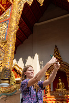 Woman Takes Selfie at Temple With Golden Decorations in Thailand