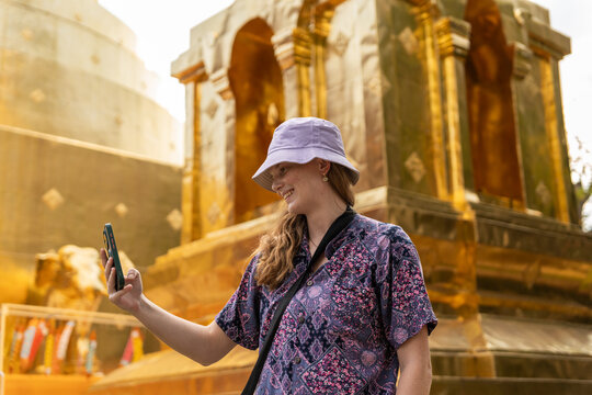 Woman Takes Selfie at a Golden Temple During Daytime