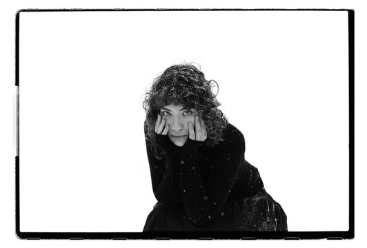Film B&W Portrait of a Woman Pressing Fingers to Cheeks in Snow